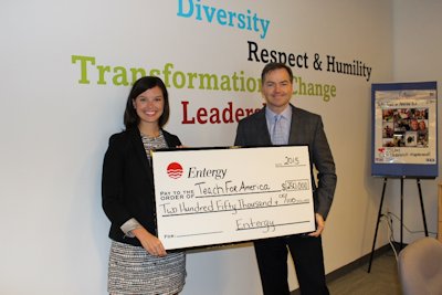 Teach for America Executive Director Laura Vinsant receives a check from Entergy Louisiana President Phillip May.